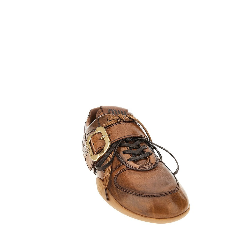 Sneakers in pelle con fibbia logata