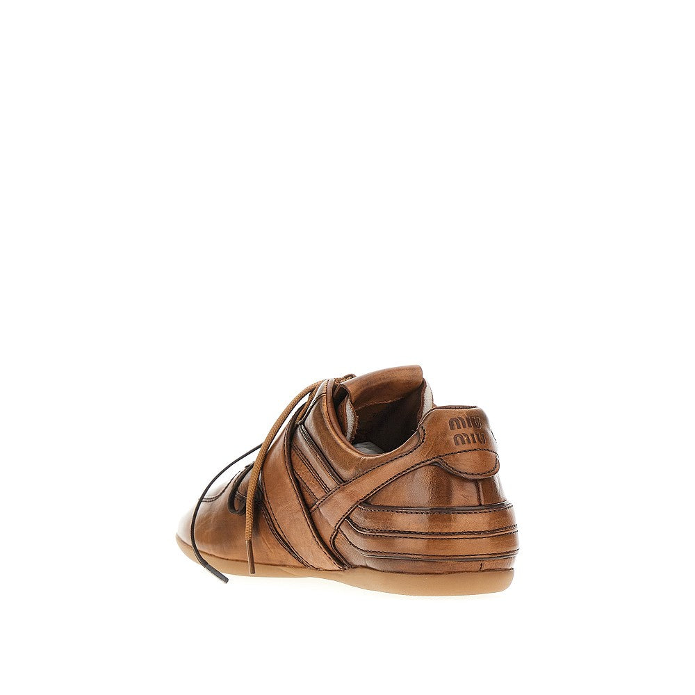 Sneakers in pelle con fibbia logata